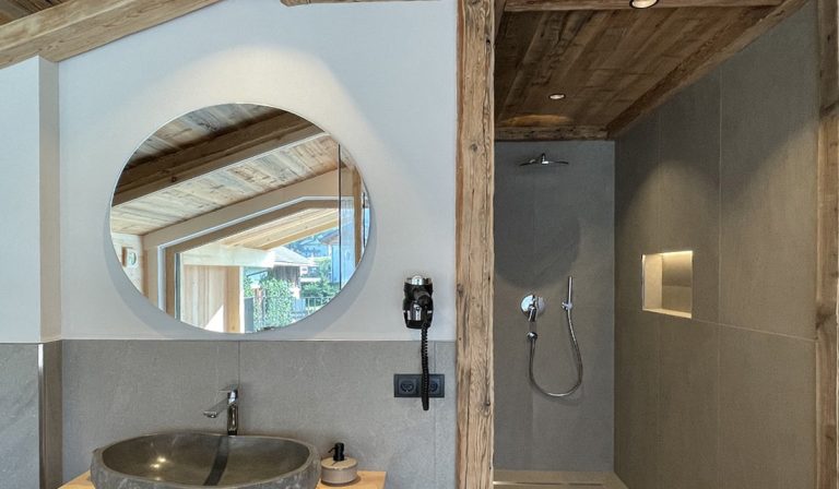 a bathroom with a round mirror and shower