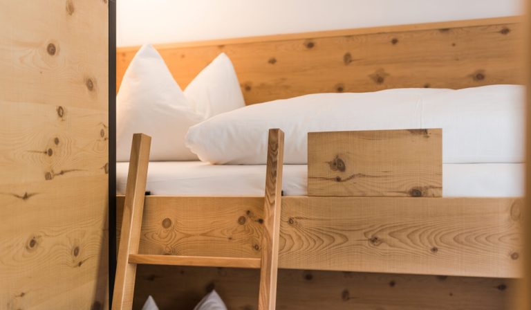 a wooden bed with white pillows