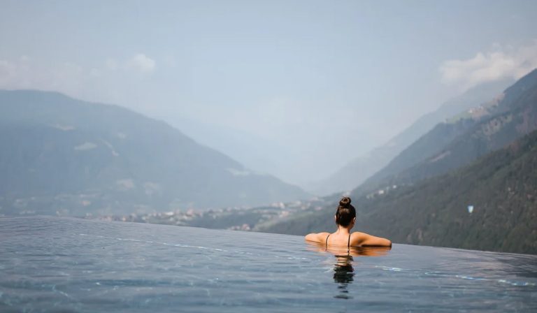 a woman in a pool overlooking a valley